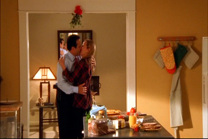 Adrian and Trudy Monk kissing under the mistletoe