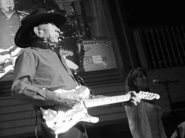 black and white photo of mature Buck Owens on stage