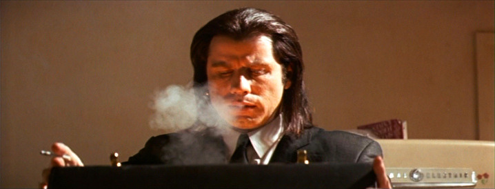 John Travolta as Vincent Vega looking into the glow of Marsellus briefcase