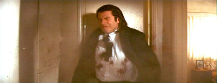 John Travolta as Vincent Vega being shot to death in Pulp Fiction
