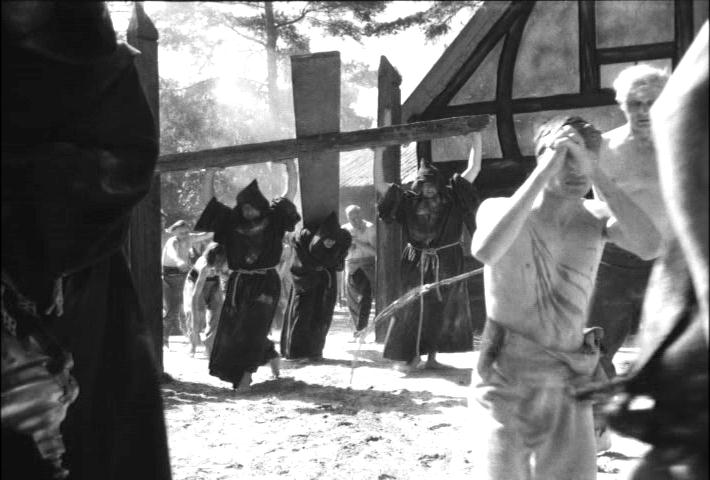 monks bearing a cross