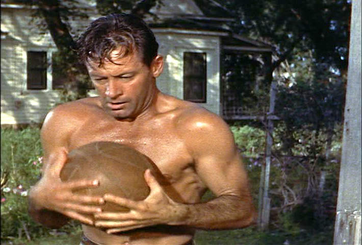 suddenly self-conscious William Holden covers his nakedness with a basketball