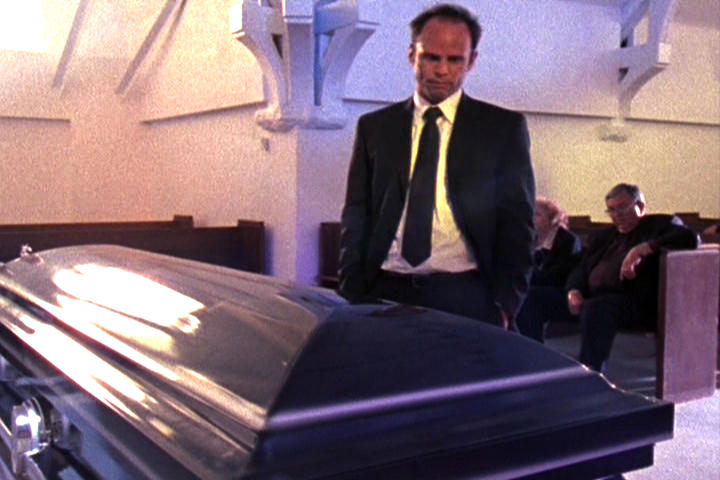 Shane Vendrell looks at his buddy's coffin that he put him in