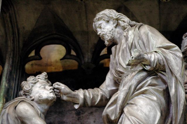 sculpture of Jesus healing the blind man's eyes with mud
