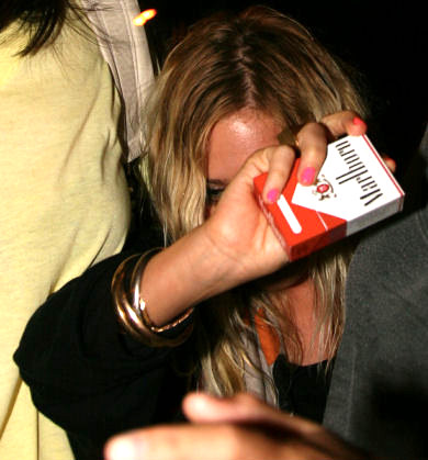 Mary-Kate Olsen hiding behind a pack of Marlboros