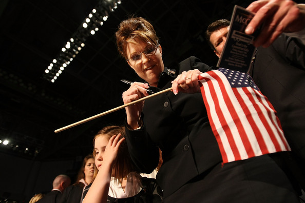 Sarah Palin autographs a flag