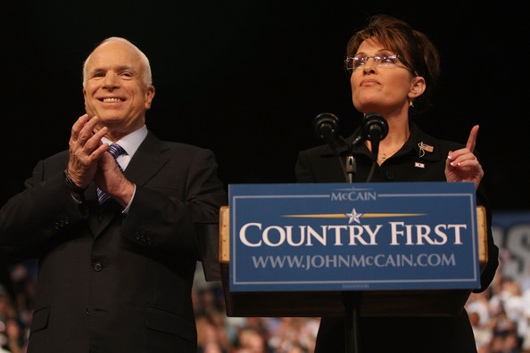 John McCain applauds as Sarah Palin makes a point