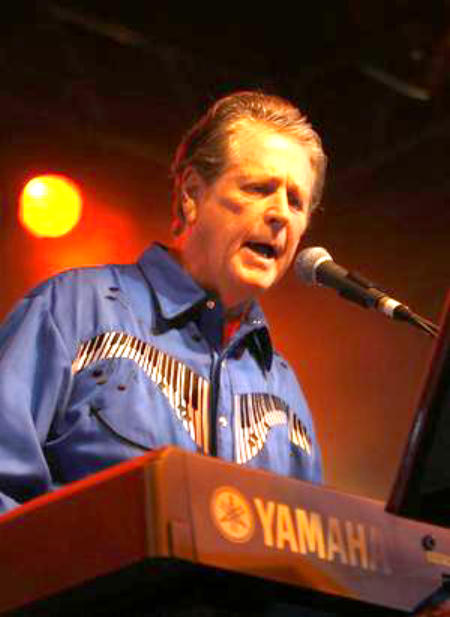 mature Brian Wilson playing keyboard on stage