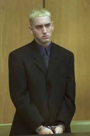 Eminem alias Marshall Mathers in suit and tie and handcuffs