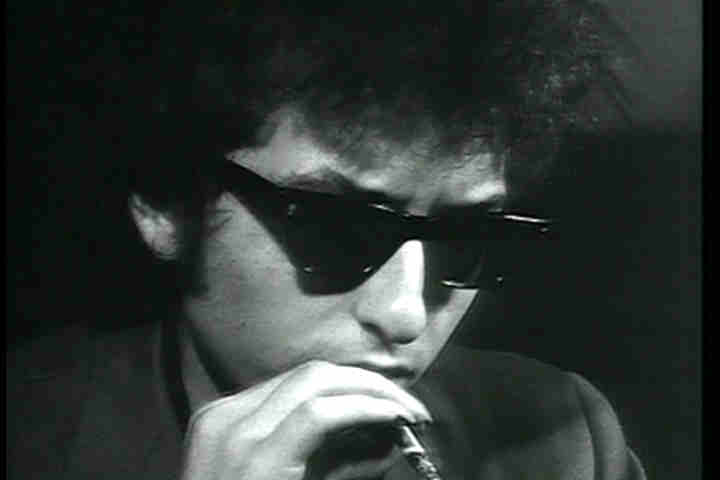 Bob Dylan in sunglasses smoking a cigarette