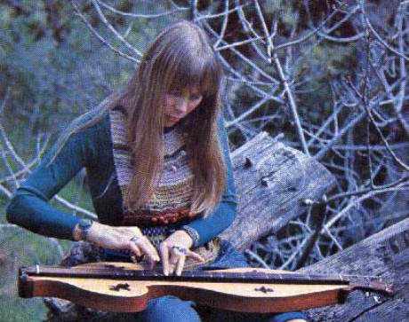 Joni Mitchell in the woods playing a stringy thingy