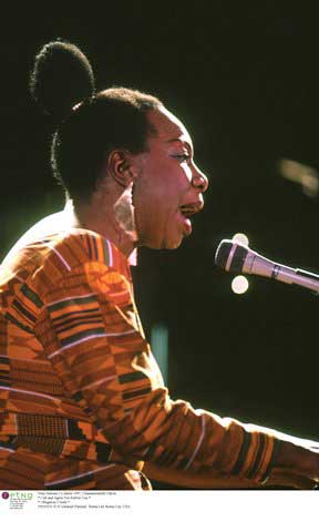 Nina Simone on stage with her hair tied back