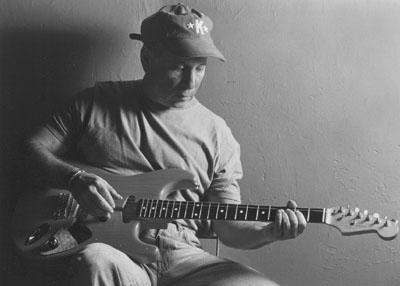 black and white picture of Paul Simon playing guitar