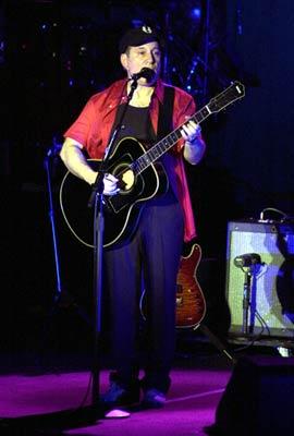 Paul Simon playing guitar on stage
