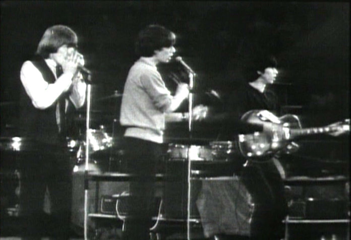 Brian Jones blowing harmonica, Mick Jagger shaking maracas and Keef playing guitar