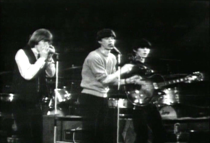 Mick Jagger playing maracas with Brian Jones and Keith Richards