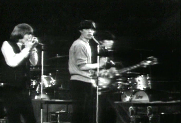 Brian Jones playing harmonica, with Mick Jagger and Keef Richards