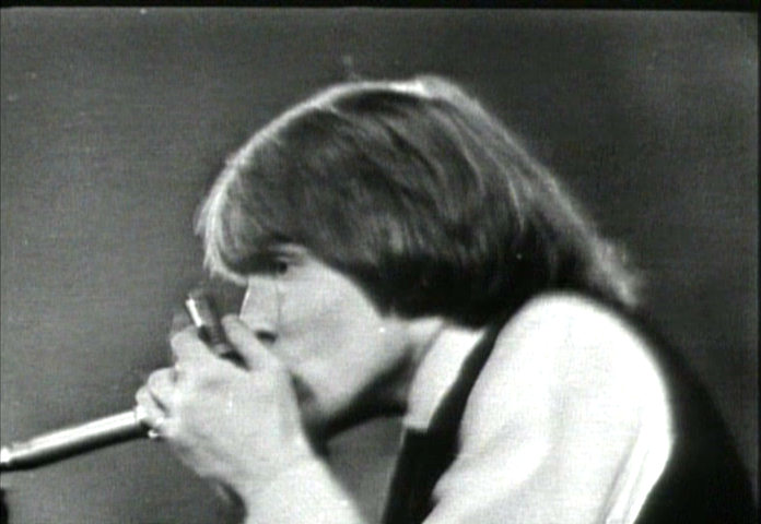 1964, Brian Jones playing harmonica on stage