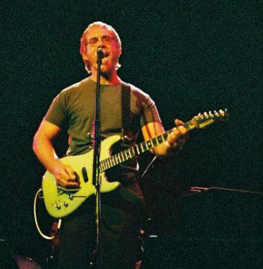Warren Zevon playing guitar onstage