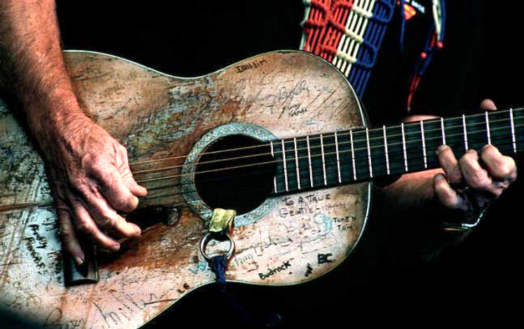 closeup of Willie Nelson's old beat up guitar